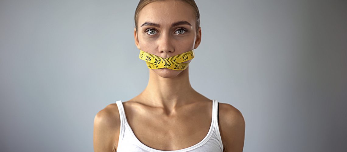 Lady with tape closing mouth looking at camera, weight loss calculating calories